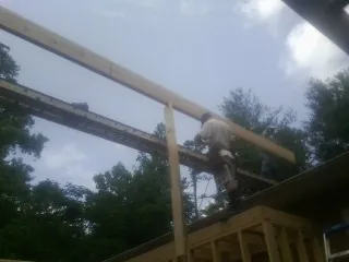 Carpenter setting a ridge beam over a new addition frame — Ice Dam Removal by Roofing Brothers in Whitmore