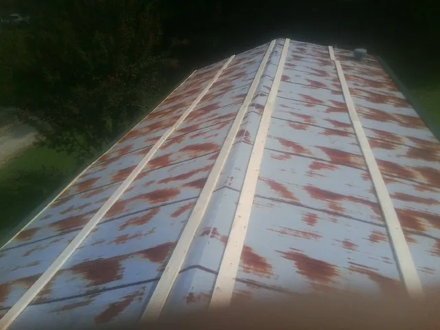 Rusted metal roof panels with new wood purlins before replacement — Storm Damage Roof Repair in Whitmore by Roofing Brothers