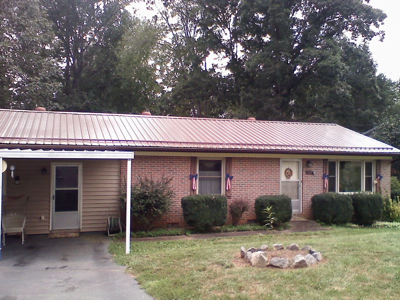 Bronze metal roof and carport on a brick ranch home — Roof Repair work by our crew in Whitmore